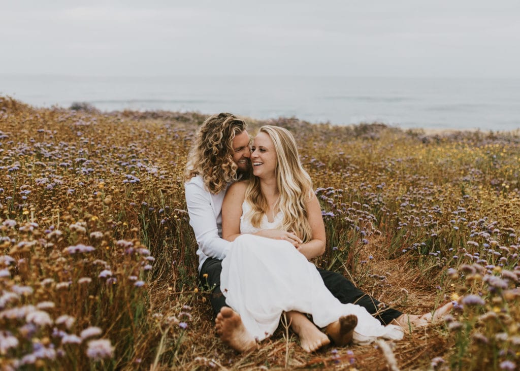 A couple snuggling at Sunset Cliffs for their elopement in San Diego.
