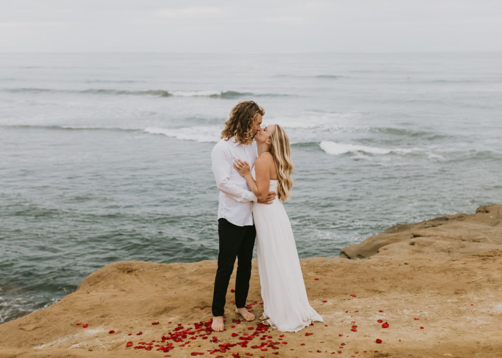 A bride and groom kissing at Sunset Cliffs in San Diego, California for their sunrise elopement, one of the best places to elope in California.
