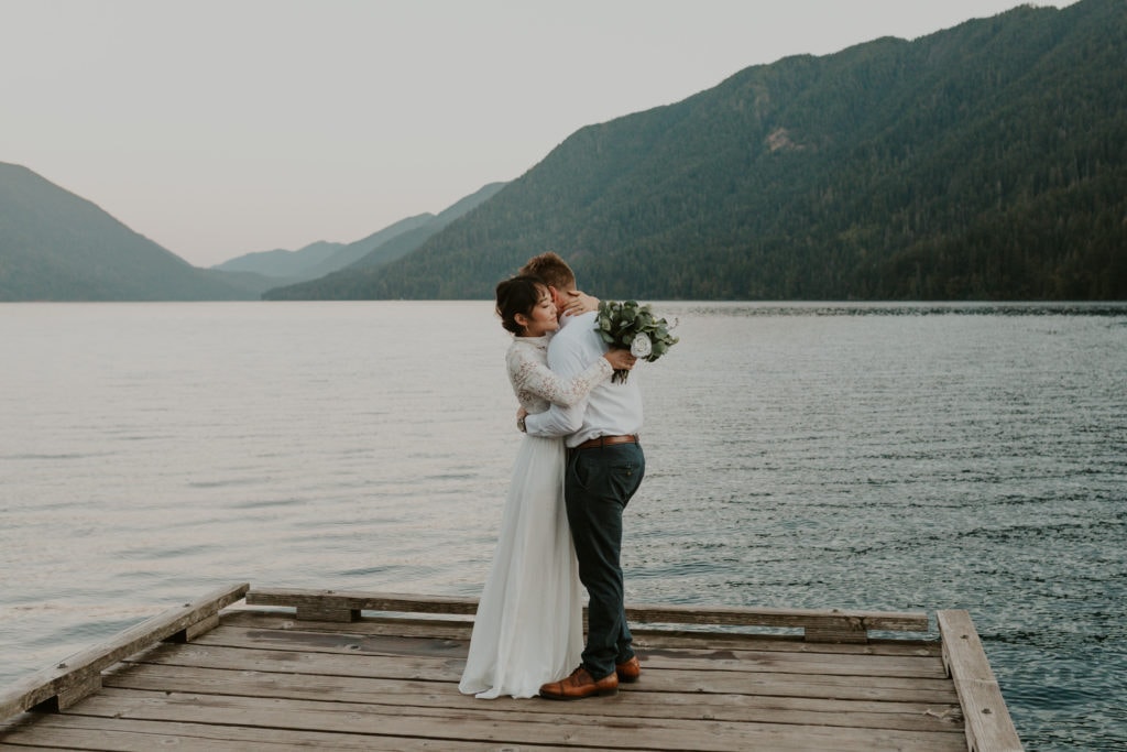 A couple hugging on their elopement day next to a lake in California.