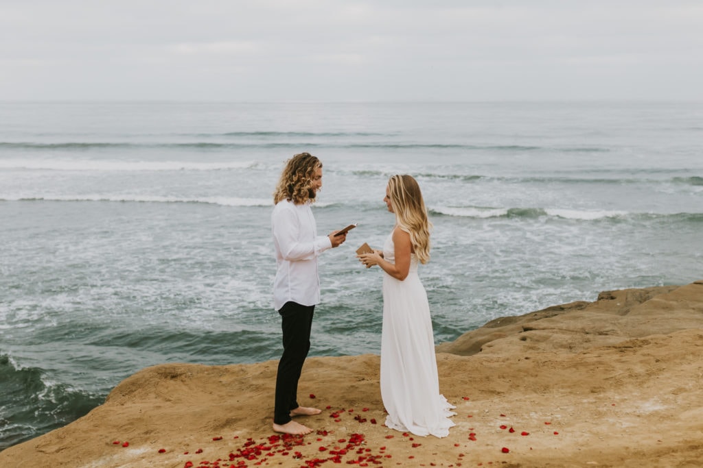 A bride and groom exchanging vows at Sunset Cliffs in California for their California elopement.
