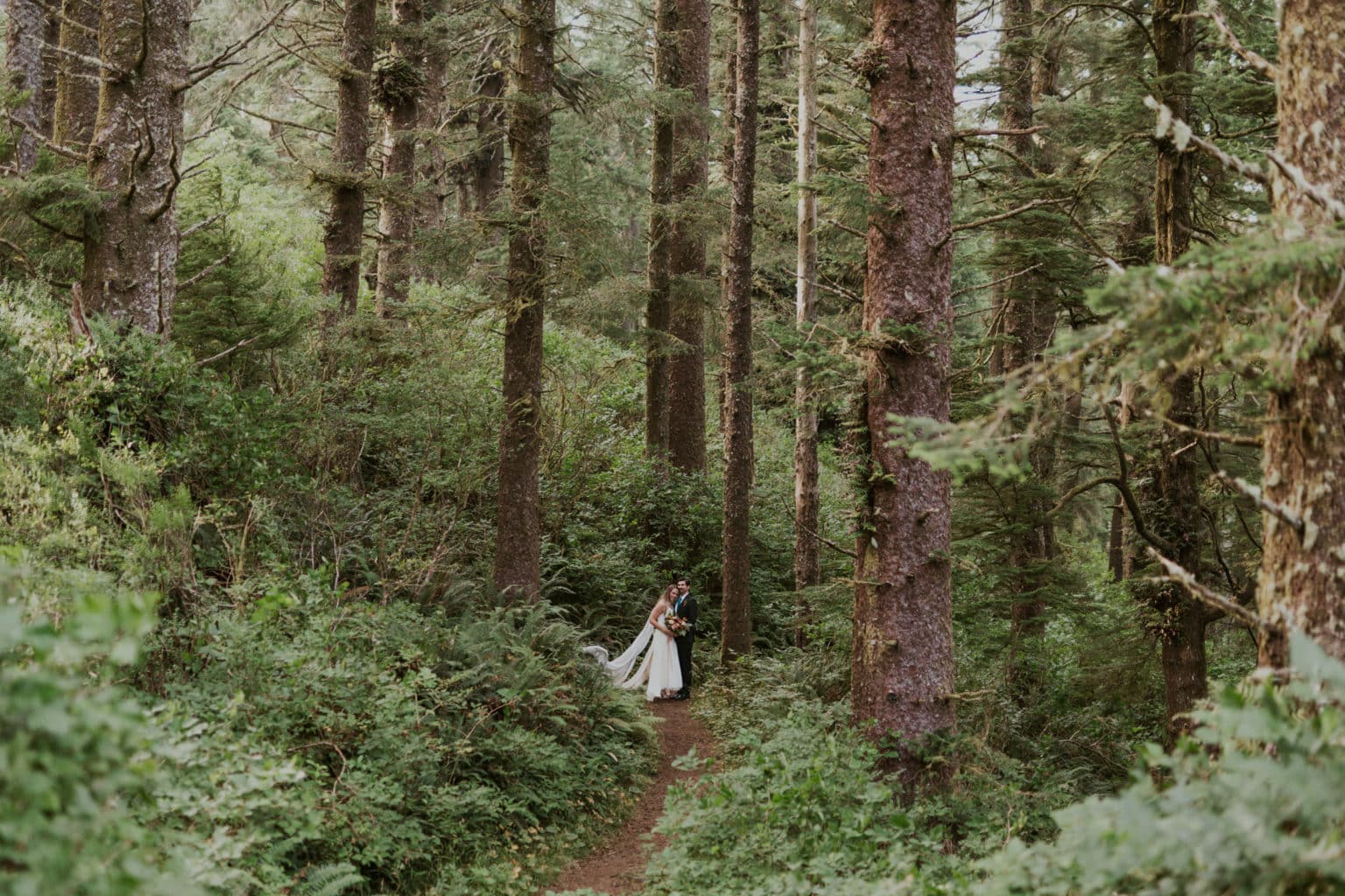 A couple hugging in an Oregon forest on their wedding day.