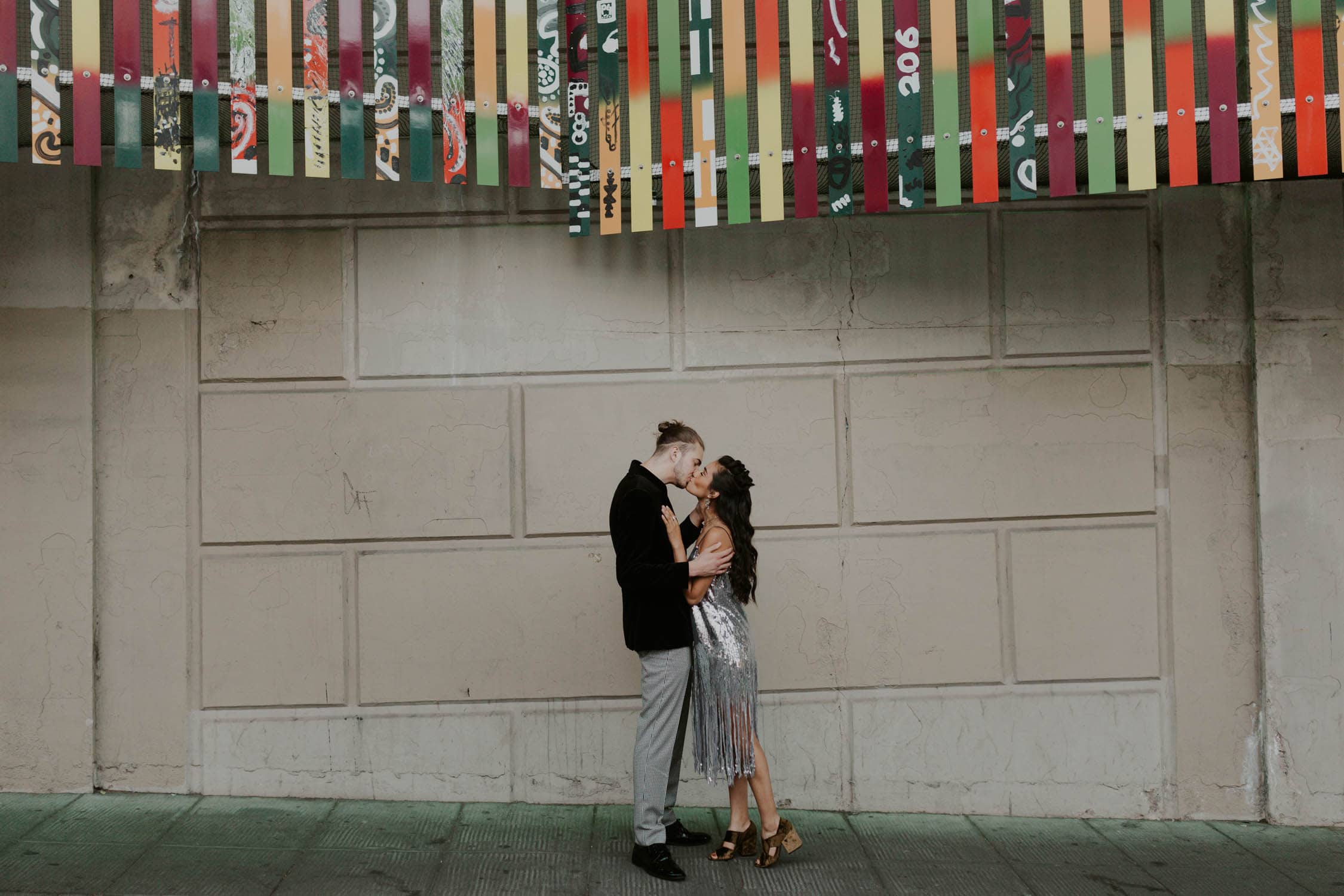 A bride and groom kissing in downtown Seattle. The bride is wearing a silver sparkly dress.