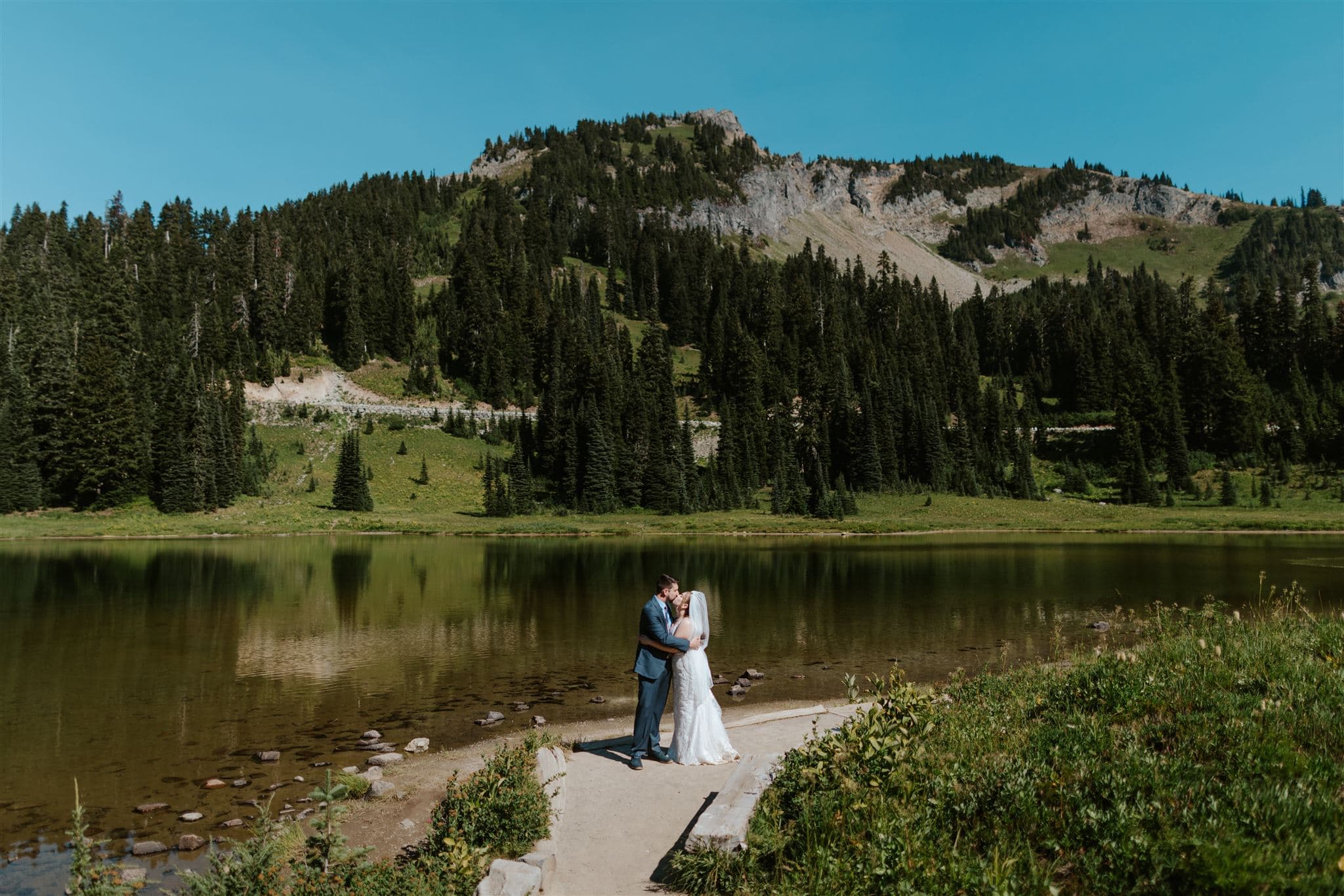 A couple in wedding attire kissing at Tipsoo Lake.