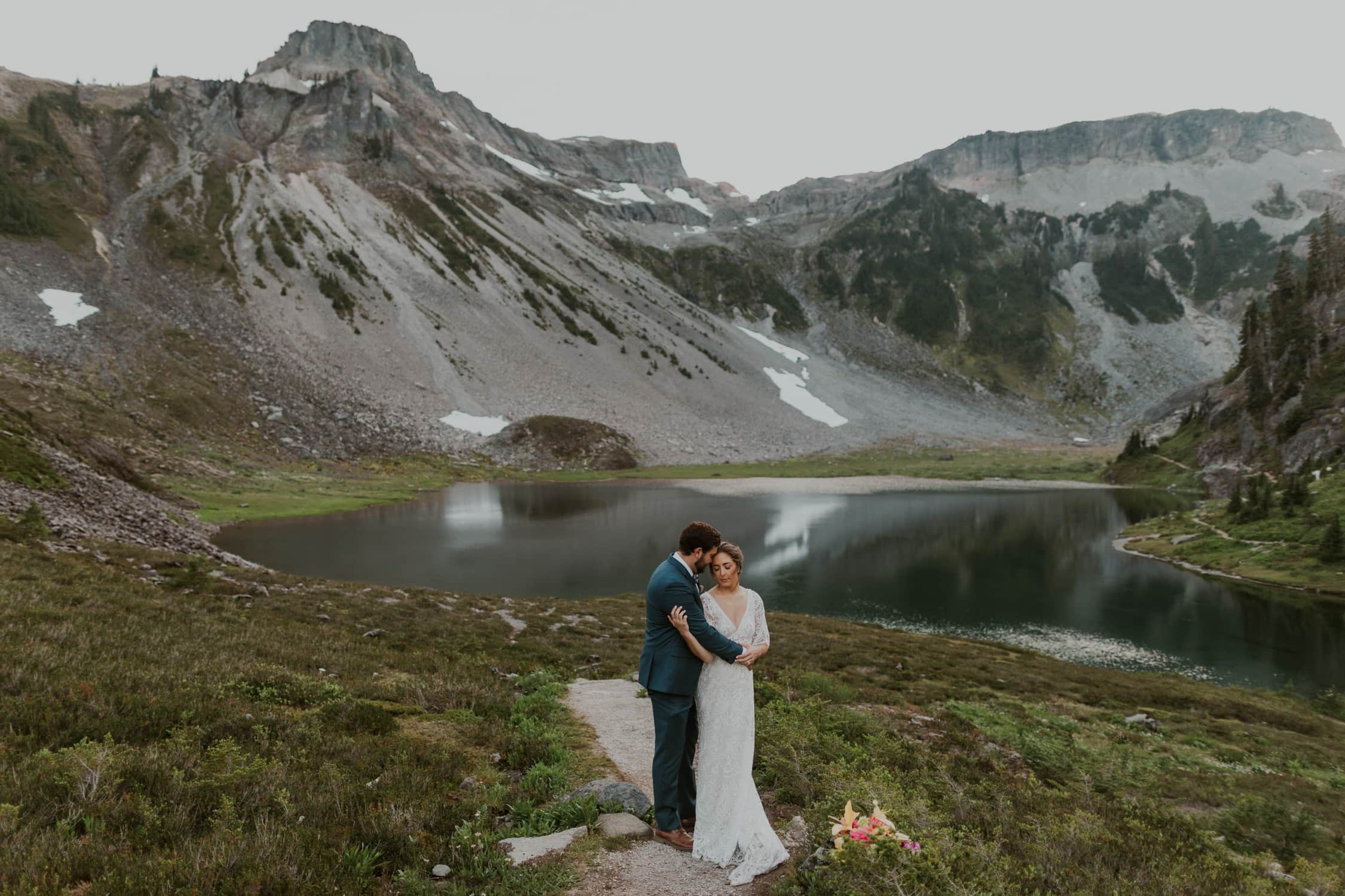 A bride and groom hugging each other in front of Bagley Lakes in North Cascades National Park.