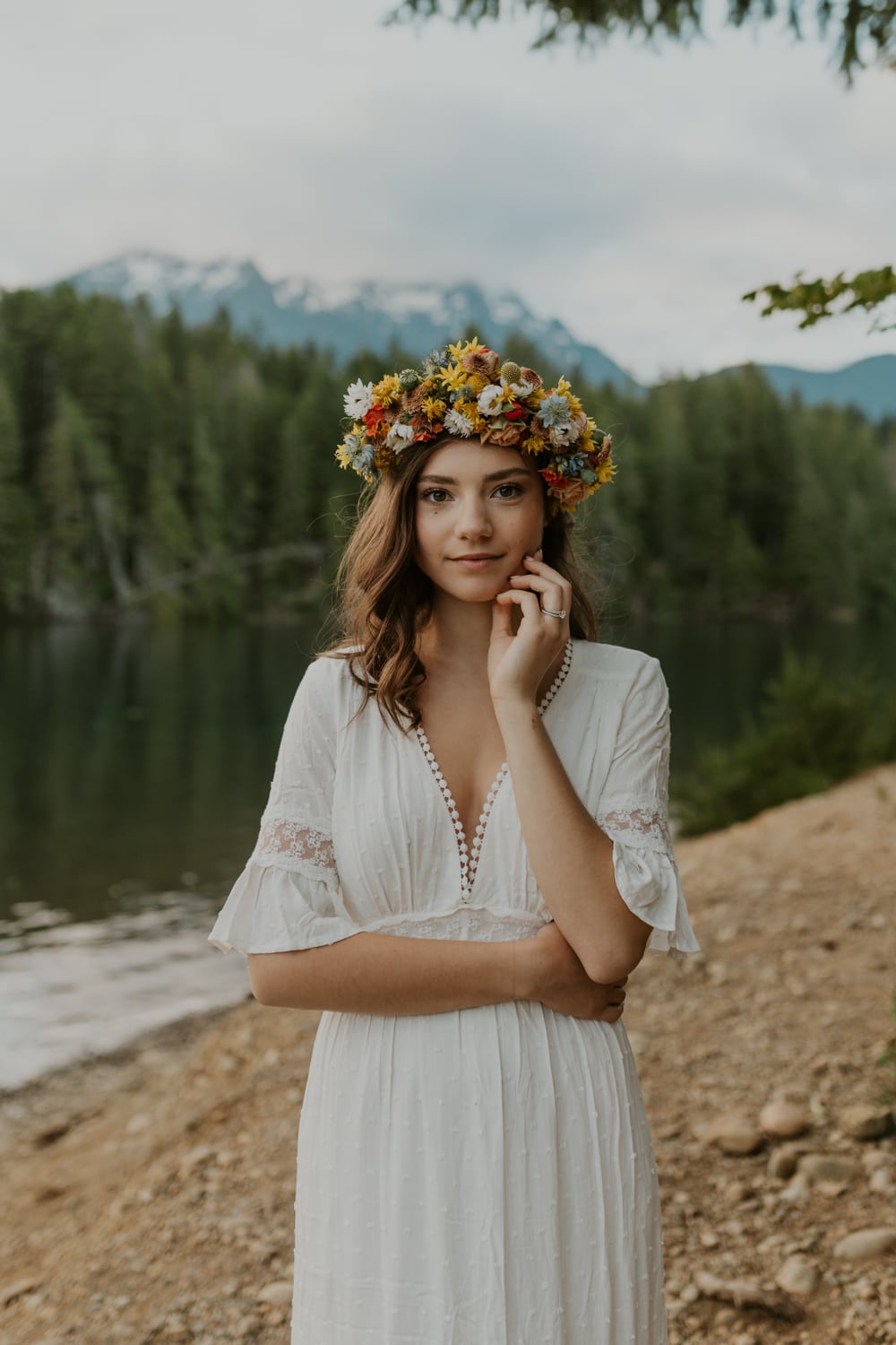A bride facing the camera at Lake Cushman wearing a flower crown.