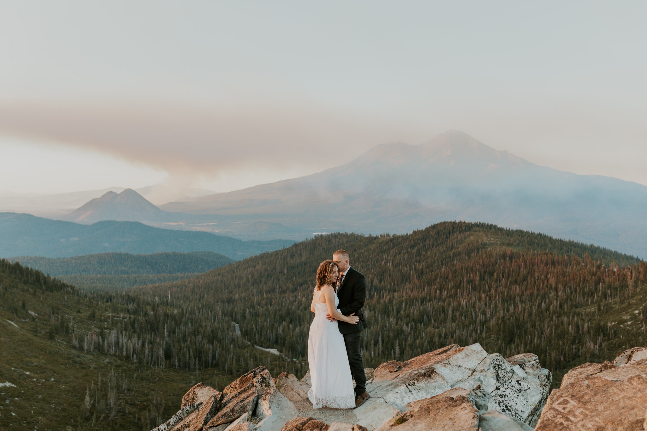 A couple hugging on a mountain for their Mt. Shasta wedding