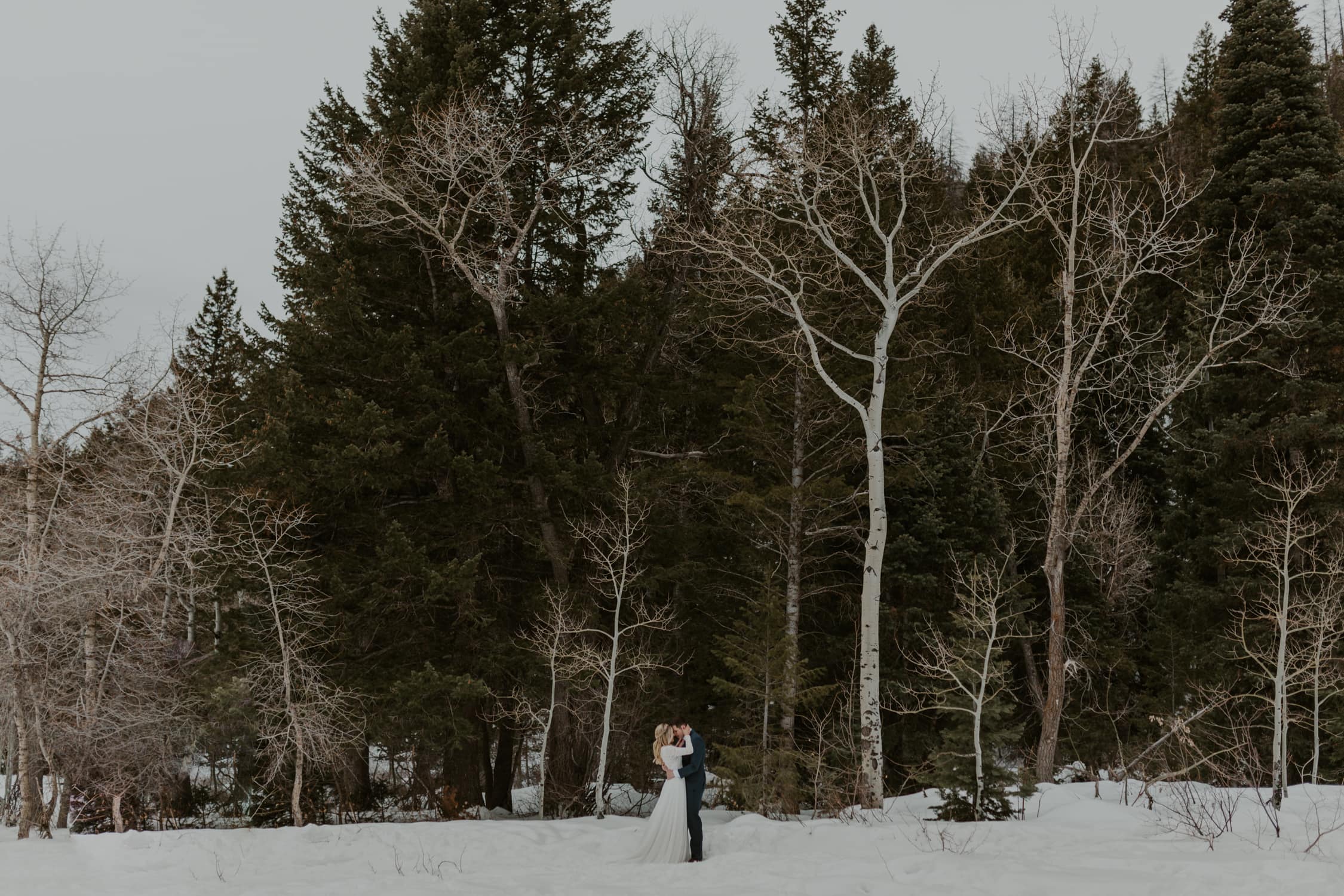 A bride and groom hugging in the snow on their elopement day.